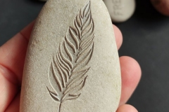 Akmens ar gravētu spalvu