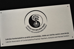 Anodēta alumīnija plāksnīte ar pulētu virsmu un mehāniski gravētu un krāsotu informāciju.