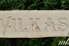 Mājas nosaukums gravēts kokā