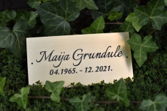 Gravēta kapu plāksne no zeltīta plastikāta.