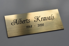 Gravēta kapu plāksne no zeltīta plastikāta.