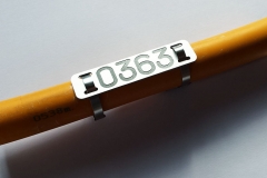 Gravēti alumīnija marķējumi kabeļiem.