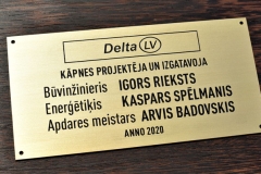 Misiņa plāksne ar gravētu tekstu. Gravējums ir krāsots melnā krāsā.