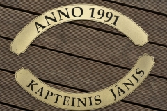 Gravēti misiņa dekori kuģīša stūrei.