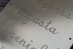 Misiņa plāksne ar gravējumu. Gravētas latvju zīmes.