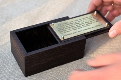 Kastīte no venges koka apstrādāta ar minerāleļļu. Misiņa plāksnīte ar gravētu tekstu.